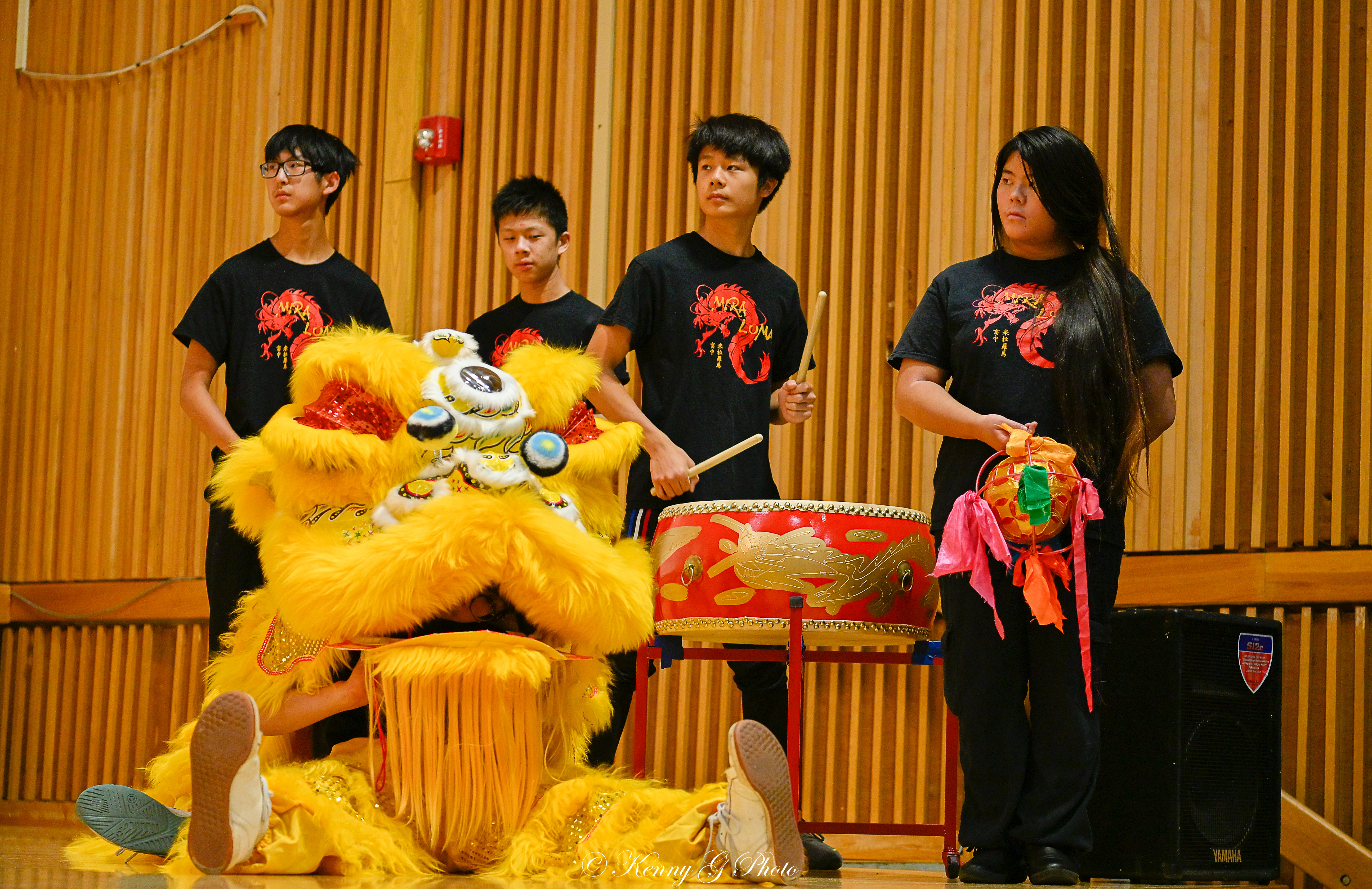 4 people in black shirts on the side of a stage