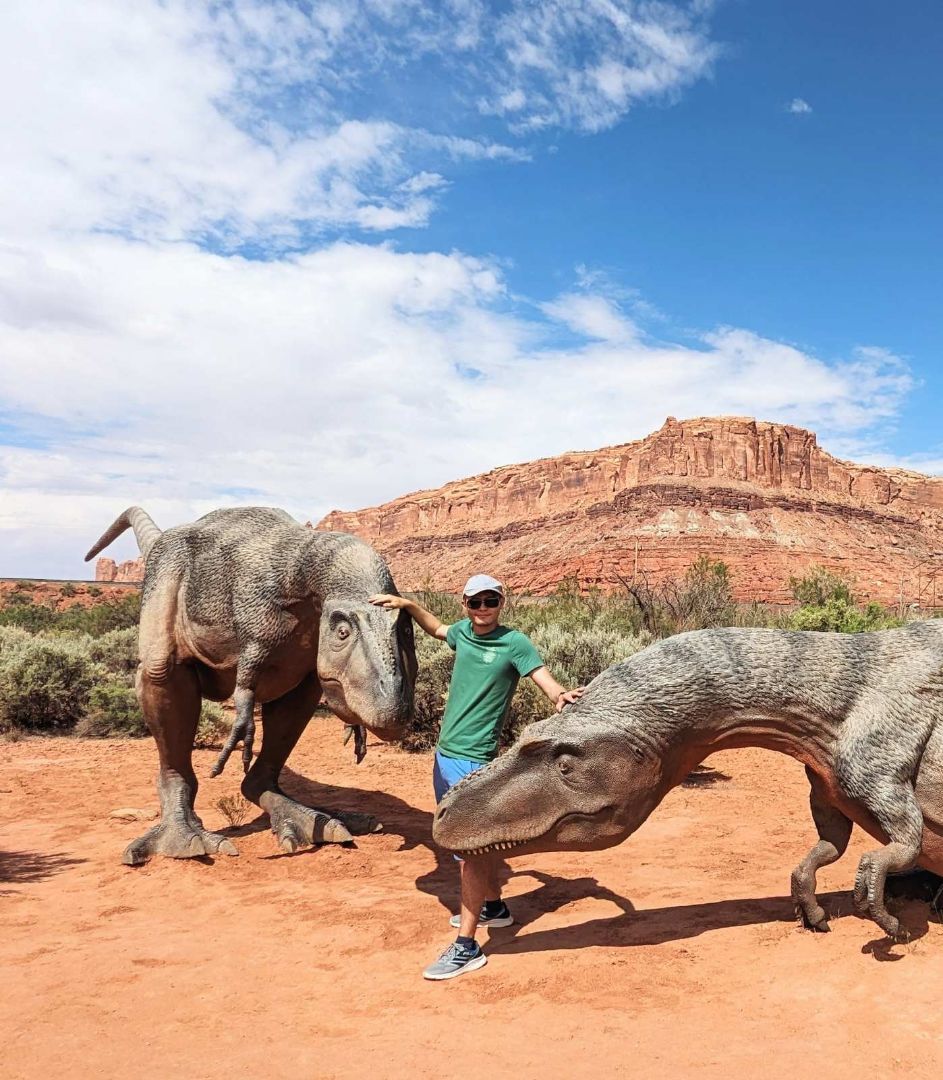 Aleksey standing with a couple of dinosaurs